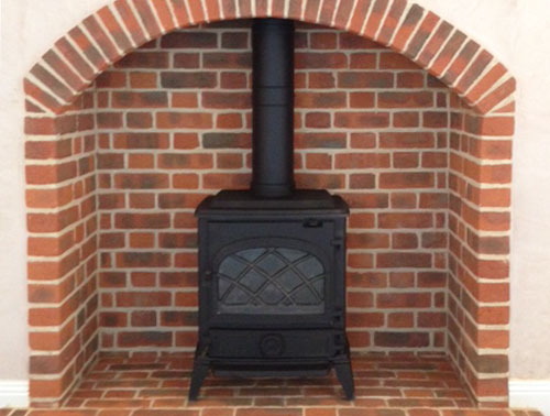 wood stove installed in brick fireplace & hearth